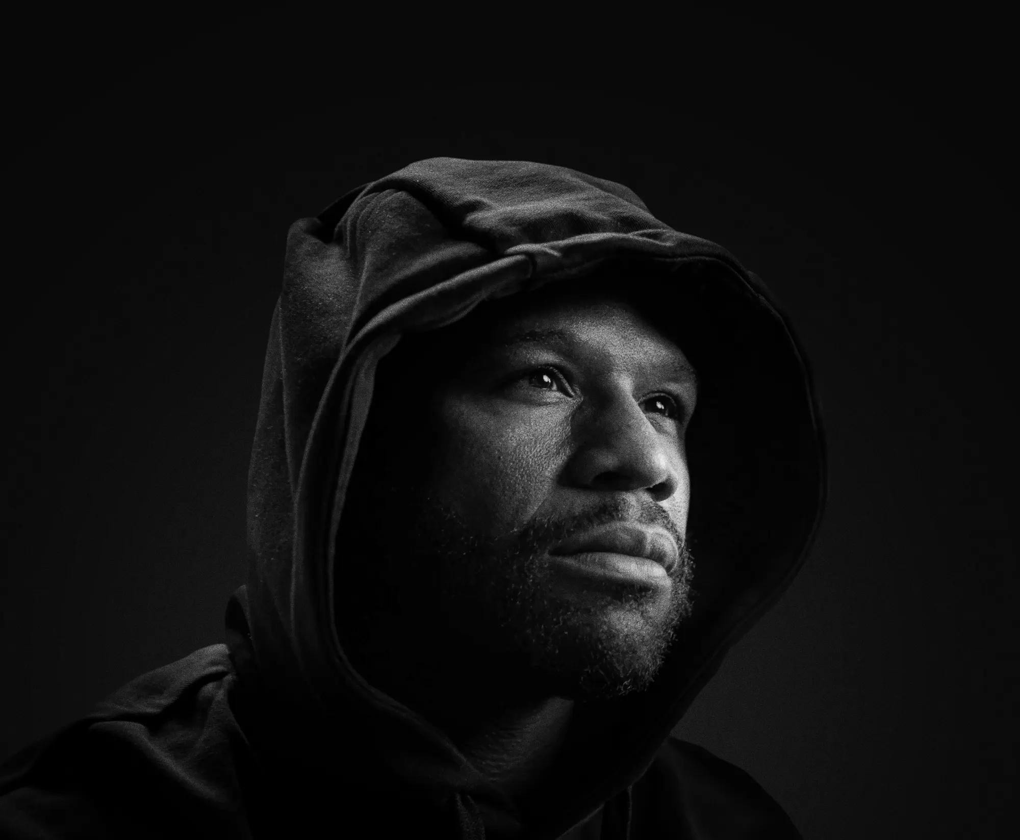 Floyd Mayweather in a black hood, black and white portrait.